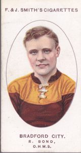 Full colour football cigarette card with head and shoulder portrait of Bradford City footballer Richard Bond, smiling and looking straight at the viewer in a red and yellow jersey.
